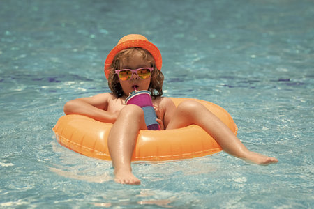 Child in swimming pool on inflatable float ring. Water toy, healthy outdoor sport activity for...