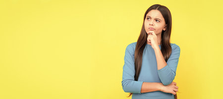 thinking teen girl with long hair on yellow background, think. Child face, horizontal poster, teenager girl isolated portrait, banner with copy space.の写真素材