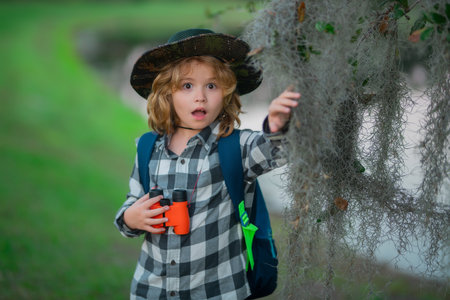 Child with backpack, traveller or explorer. Concept of exploration and discovery. Kid travel on nature outdoors, adventure and tourism, leisure trips. Travel and adventure vacation.の写真素材