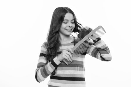Teenage girl with brush combing hair. Girl taking hairstyle. Child brushing hair with comb, kids...