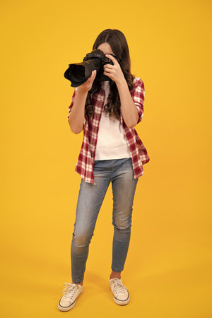 Teenager girl photographer with a dslr camera. Kid use digital camera. Child photographing. School of photography. Kid photographer beginner.の写真素材
