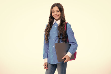 Teen schoolgirl hold laptop on isolated studio background. Cchool student learning online, webinar,...