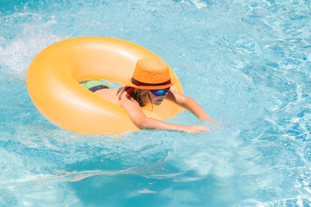 Child playing in swimming pool. Kids holidays and vacation concept. Summer kids cocktail. Happy...
