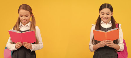 School girls friends. Little children in school uniforms read library books yellow background, reading. Banner of school girl student. Schoolgirl pupil portrait with copy space.の写真素材