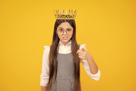 Girls birthday party, funny kid in crown. Imagine herself a queen, child wear diadem. Successful teenager wear luxury beauty queen crown, success. Angry teenager girl, upset and negative emotion.の写真素材