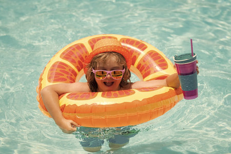 Child in swimming pool on inflatable float ring. Water toy, healthy outdoor sport activity for...