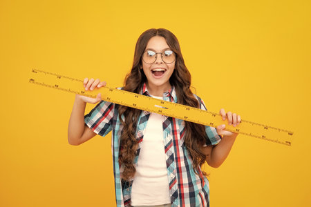 Back to school. Teenager school girl on yellow isolated background. School supplies.