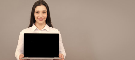 Woman isolated face portrait, banner with mock up copy space. woman showing laptop screen. modern...