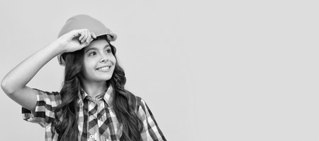 improve your childhood. future engineer. workers day. making repairs. cheerful teen girl. Child builder in helmet horizontal poster design. Banner header, copy space.の写真素材