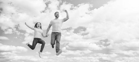 Father and daughter jump on sky, banner with copy space. happy father and daughter jump in sky. family supportの写真素材