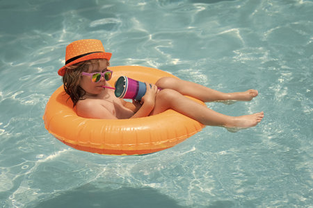 Happy child playing in swimming pool. Summer vacation concept. Summer kids portrait in sea water on...