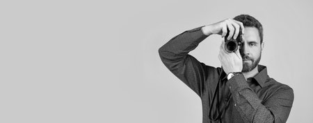 Amateur photographer shoot picture with handheld photo camera grey background, shootingの写真素材