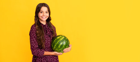 happy child hold water melon. watermelon on yellow background. kid with fruit. Summer girl portrait with watermelon, horizontal poster. Banner header with copy space.の写真素材