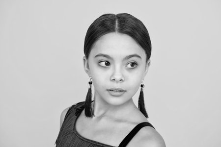 Pretty teen girl headshot portrait. Adorable little girl child isolated on a yellow background.の写真素材