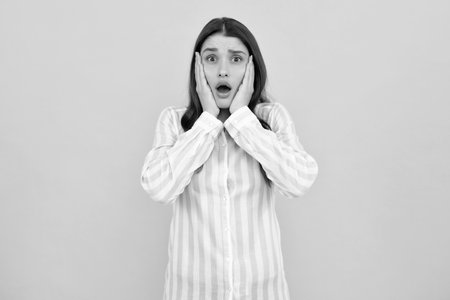 Surprised astonished young woman with open mouth. Excited female face. Portrait of excited amazed gasping girl. Expressive facial expressions.の写真素材