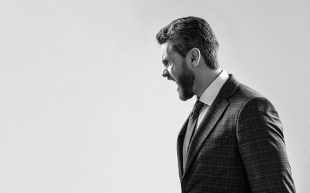 You make me yell. Angry guy side-face yell grey background. Businessman scream in angerの写真素材