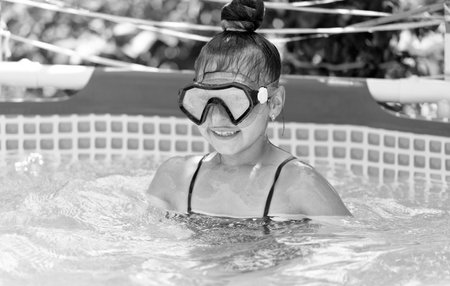 Happy girl child wear swimming mask in outdoor pool in summer, swimの写真素材