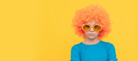 feeling unhappy. eing a clown. april fools day. happy childhood. girls birthday party. Funny teenager child in wig, party poster. Banner header, copy space.の写真素材