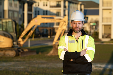 Construction man industry with excavator at industrial site. Worker in helmet build with bulldozer....