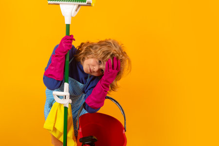 Child use duster and gloves for cleaning. Funny child mopping house. Cleaning accessory, cleaning supplies. Housekeeping and home cleaning.の写真素材