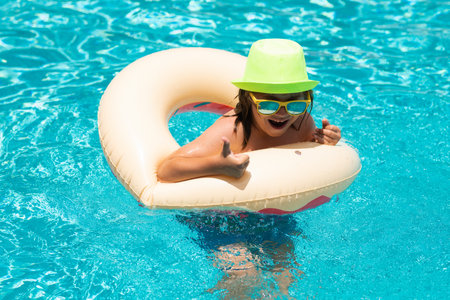 Happy child enjoying summer vacation outdoors in the water in the swimming pool.の写真素材