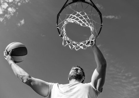 summer activity. strong man with basketball ball on court. professional basketball playerの写真素材