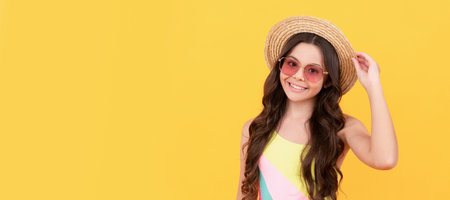 smiling child wear straw hat and glasses. cheerful little girl on yellow background. Child face, horizontal poster, teenager girl portrait, banner with copy space.の写真素材