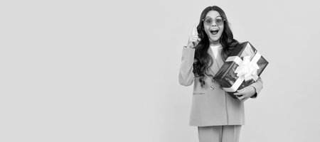 trendy inspired with idea teen girl in sunglasses and suit hold present box full length, inspiration. Kid girl with gift, horizontal poster. Banner header with copy space.の写真素材