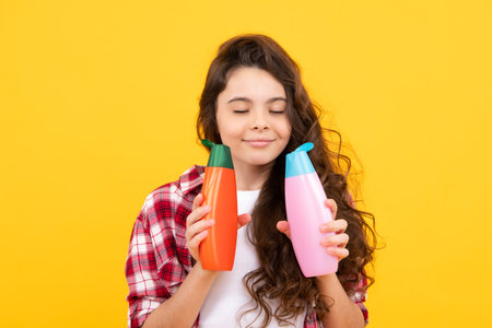 Teenage girl with shampoos conditioners or shower gel. Kids hair care cosmetic product, shampoo bottle.の写真素材