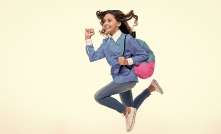 School girl with backpack. Teenager student, isolated background. Learning and knowledge. Go study. Run and jump. Children education concept.の写真素材