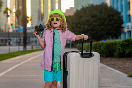 Child with travel suitcase on vacation. Kids travel and adventure concept. Child boy going on vacation holding luggage travel bag outdoor.の写真素材