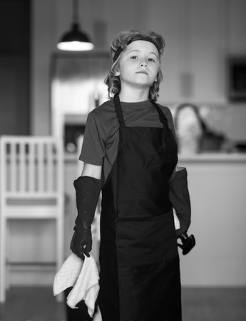 Portrait of child helping with housework, cleaning the house. Housekeeping, home chores.の写真素材