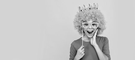 happy childhood. girls birthday party. happy funny kid in curly wig and crown. Funny teenager child in wig, party poster. Banner header, copy space.の写真素材