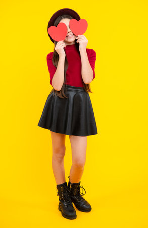 Happy teenager portrait. Lovely child teen girl with shape heart love holiday and valentine symbol. Valentine or birthday day. Gift heart present. Smiling girl.の写真素材