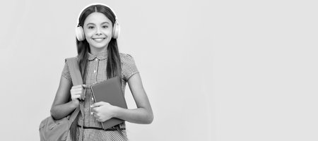 happy childhood. child with school bag. music. happy teen girl carry backpack. Portrait of schoolgirl student, studio banner header. School child face, copyspace.の写真素材