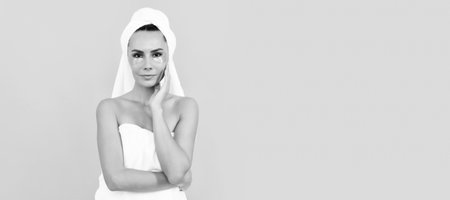 Woman with beauty face, facial skin portrait. Woman isolated face portrait, banner with copy space. applying mask. girl reduce eye bags. skincare. facial collagen cosmetic. moisturizing skin.の写真素材
