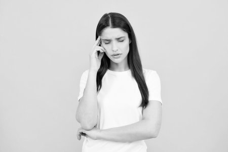 Portrait of young woman feeling stress or strain headache. Exhausted tired girl desperate and stressed because pain and migraine. Upset sad depressed model with hands on head.の写真素材