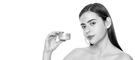 Beauty woman skin. Woman beauty face, close up portrait, isolated banner with copy space. young lady showing cream jar for face skin isolated on white with copy space, moisturizing balsam.の写真素材