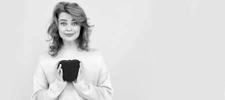 Woman isolated face portrait, banner with copy space. smiling redhead girl with red heart on yellow background.の写真素材
