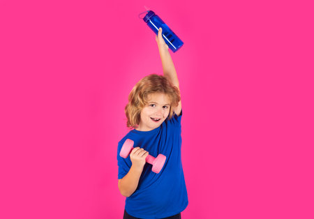 Sporty kids, studio isolated portrait. Cute child boy pumping up arm muscles with dumbbell. Fitness kids with dumbbells.の写真素材