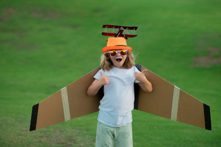 Happy boy play in airplane outdoors. Concept of dreams and travels. Dreams of flying planes.の写真素材