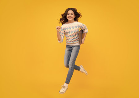 Young girl student hold computer. Funny pupil with laptop isolated on yellow background. Run and...