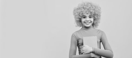 Enjoying school life. Happy girl smile holding book. Back to school. Literacy education. Funny teenager child on party, poster banner header with copy space.の写真素材
