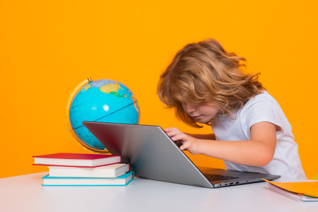 School child using laptop computer. School kid 7-8 years old with book go back to school. Little student. Education concept.の写真素材