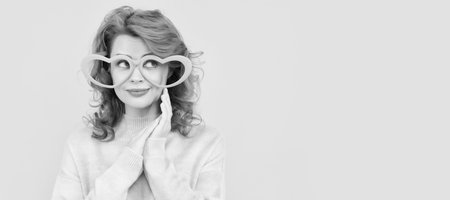 Woman isolated face portrait, banner with copy space. happy redhead woman wear funny party glasses on yellow background, party.の写真素材