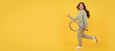 happy energetic kid jump in sportswear with tennis racket running to success, active childhood. Horizontal poster of isolated child face, banner header, copy space.の写真素材
