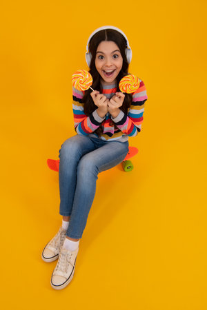 Teenage girl with lollipop, child eating sugar lollipops, kids sweets candy shop. Excited teenager girl. Happy teenager, positive and smiling emotions of teen girl.の写真素材
