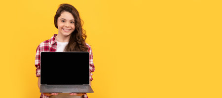 school presentation on computer. kid ready for video lesson. School girl portrait with laptop, horizontal poster. Banner header with copy space.の写真素材