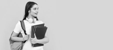 positive student hold notebook. girl holding notebook on yellow background. private teacher. Woman isolated face portrait, banner with copy space.の写真素材