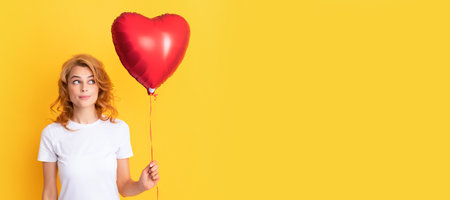thinking redhead girl with love heart balloon. charity and donation. Beautiful woman isolated face portrait, banner with mock up copy space.の写真素材